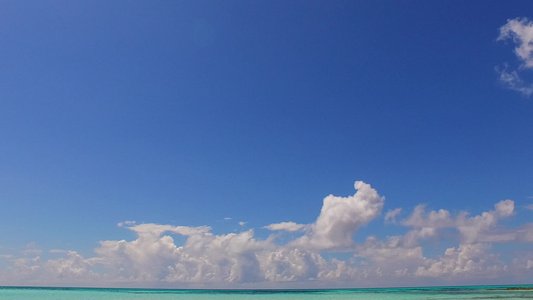 蔚蓝的海洋和靠近冲浪的白色沙滩背景的美丽海滨海滩之旅视频