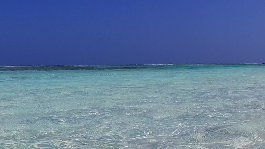 阳光下浅海白沙背景的天堂海岸线海滩航行阳光景观视频