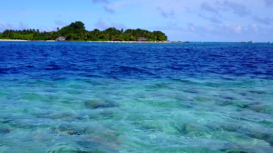 靠近海浪的蓝色大海和白色沙滩背景的美丽海湾海滩之旅视频