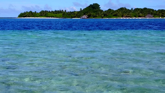 靠近海浪的蓝水和白沙背景特写豪华度假村海滩时间的质感视频