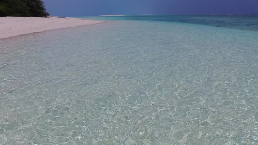 清澈的海水和礁石附近明亮的沙滩背景下的海洋度假村海滩视频