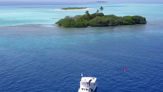 清澈的环礁湖和靠近海浪的白色沙滩背景为旅游海滩度假视频