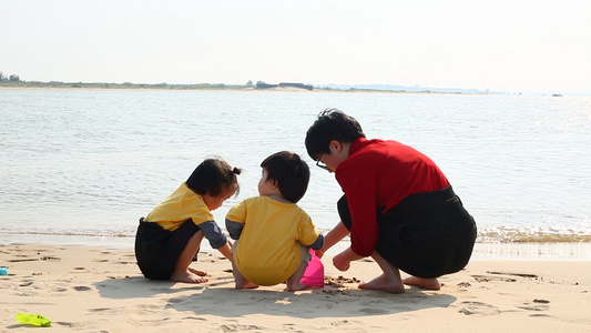妈妈带孩子在海边玩沙子视频