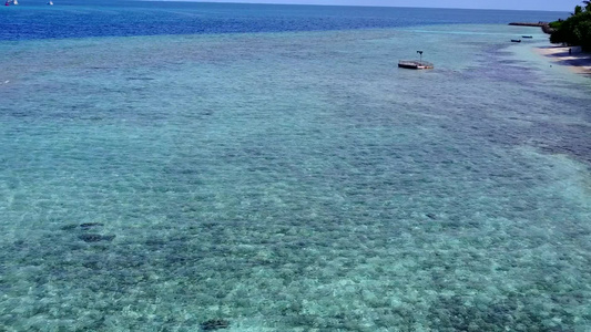 蓝色环礁湖和靠近度假胜地的白色沙滩背景清空光滑海滨视频