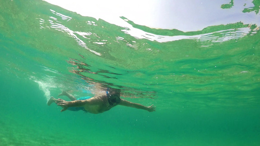 在海水表面游泳寻找宝藏Gopro半水下风景的Gopro视频