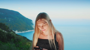 妇女使用智能手机在背景中与海洋相伴13秒视频
