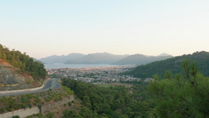 海景观与天际线背景上的山剪影汽车道路在海面和青山景观16秒视频