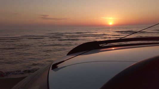 日落时在海滩上驾驶白色SUV车在沙滩上驾驶视频