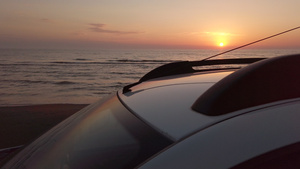 日落时在海滩上驾驶白色的车30秒视频