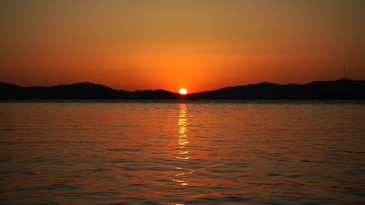 海面上有一个美丽的红色日落的海景视频