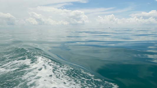 在阴天的小船和平静的海洋之后的小泡沫蓝色波浪田园诗视频