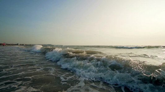 沙滩上缓慢运动的海浪海上喷洒泡沫视频