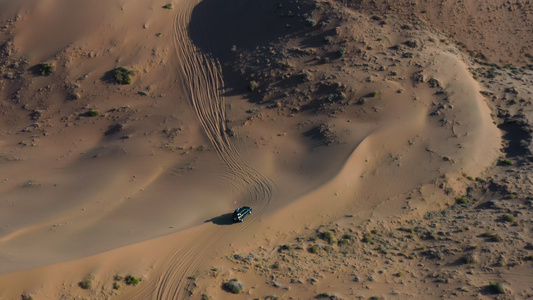 航拍腾格里沙漠中奔驰的越野车4k视频视频