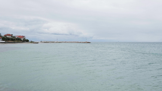 无人驾驶飞机飞越平静的海面海浪冲入海岸视频