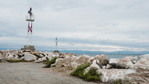 在岩石海滩和平静的海水上小型灯塔22秒视频