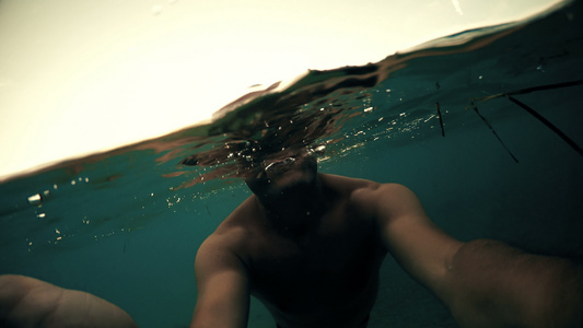在水面上游泳的人的私自和日落的太阳在背景Gopro视频