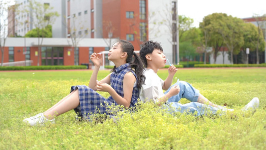 孩子们坐在草地上吹泡泡视频