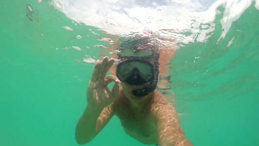 穿戴面具在海上潜水用手指举起手势标志的胸罩和佩佩特视频