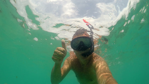 戴面具在海中潜水用手指示好手势标志的滑行男子7秒视频