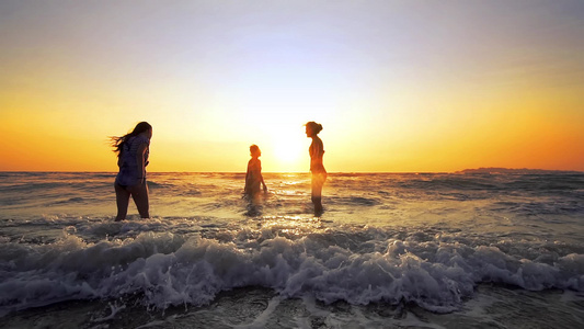一群快乐的少女在日落时在海滩上玩水美丽快乐的少年朋友视频