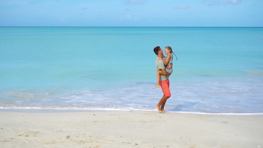 小女孩和快乐的爸爸在沙滩度假期间玩得开心视频