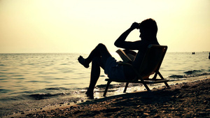 日落海边坐在椅子上阅读18秒视频