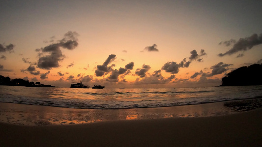 海浪撞击海滩船底云层飞速移动日出的金光照亮天上天上视频
