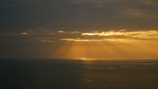 海浪下日落时阳光照耀着天空的光束视频