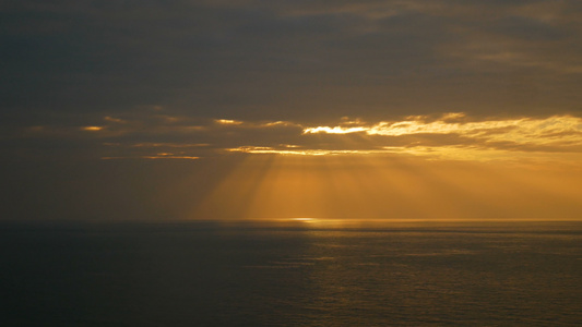 海浪下日落时阳光照耀着天空的光束视频