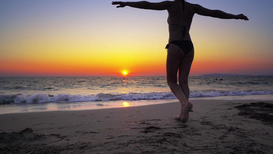时装模特女人走入海洋日落水中双手张开自由概念稳定电影视频