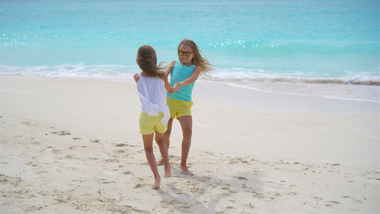 可爱的小女孩在白色热带沙滩上玩得开心视频