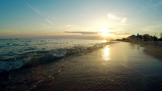 海浪在日落时喷洒沙滩沙子视频