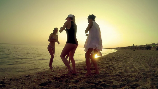 一群快乐的年轻人在海滩上跳舞......在美丽的夏日视频