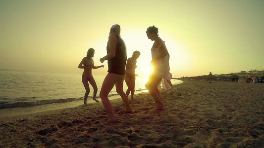 一群快乐的年轻人在海滩上跳舞......在美丽的夏日视频