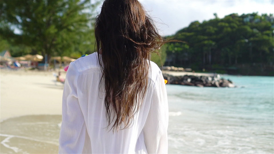 年轻美女在热带海岸玩得开心快乐女孩在白色沙滩上走来走去视频