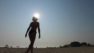 美丽的女性时装模特的轮光影在沙滩上健体行走18秒视频