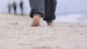 一名十几岁的少年赤脚在海滩上散步13秒视频