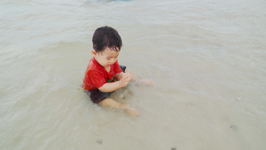 小男孩在海边的海滩上玩耍13秒视频
