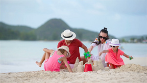 家庭在热带白色海滩建造沙滩城堡7秒视频