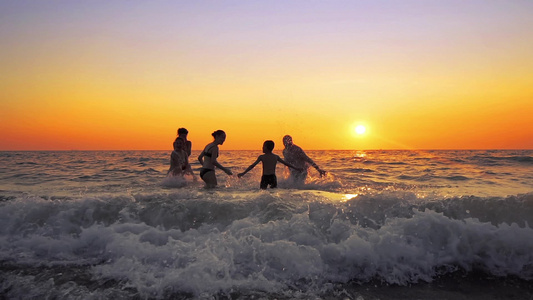 日落时在海滩派对上玩喷洒的一群年轻嬉皮士视频