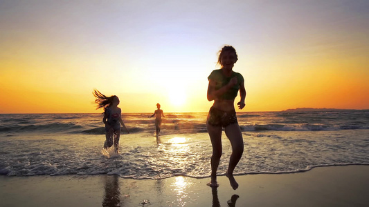 三名女性青少年在日落时分在热带海滩上耗尽海水电影替身视频