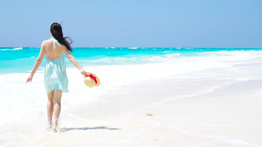白色沙滩热带海滩上的年轻美女帽子背景海中的caucasian视频