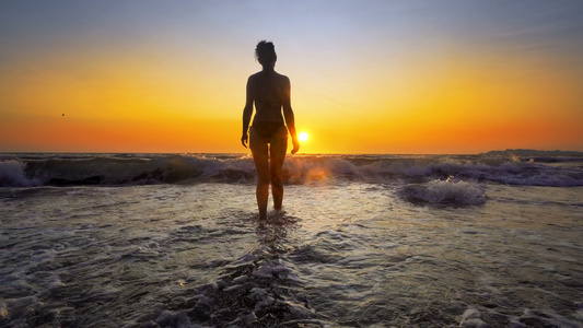 女人的脚影在海水中流淌由海浪冲向日落电影制片人Standicam视频