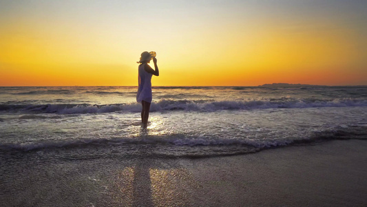 日落时在海滩上微笑自由和幸福的女人她在户外旅行假期视频