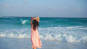 日落时在海边穿着衣服的年轻美女13秒视频