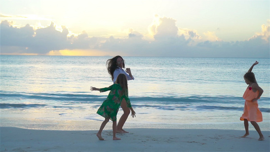 可爱的小女孩和年轻妈妈在白沙滩玩得开心慢动作视频