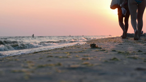 人们在日落的光线下沿着海岸行走9秒视频