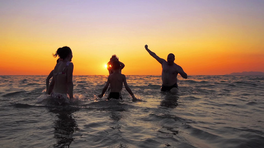 在夏季海滩日落电影慢动作上家庭正在狂欢舞蹈演唱和跳跃视频