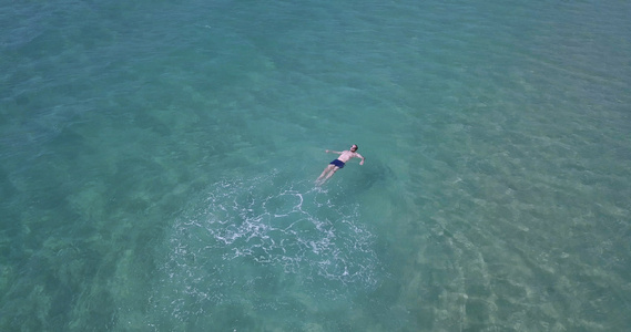 无人驾驶飞机射杀一个在海中游过游泳的男子绿绿石清澈视频