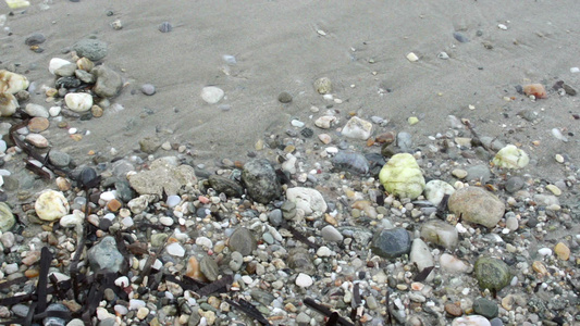 白色沙滩岸边岩石上的小海浪相近视频